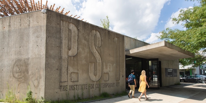 A man and woman walk past MoMA's contemporaru P.S. 1 art gallery
