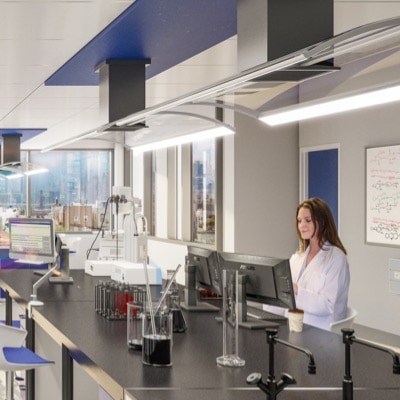 A brunette woman scientist works on a computer in a lab